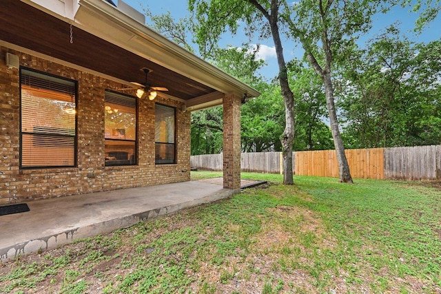 view of yard with fence, a patio, and ceiling fan