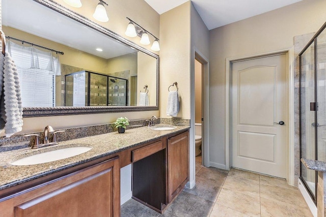 full bath featuring double vanity, toilet, a sink, and a stall shower