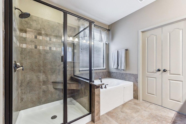 bathroom with tile patterned floors, a shower stall, and a garden tub