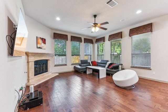 living area featuring a ceiling fan, visible vents, hardwood / wood-style flooring, recessed lighting, and a premium fireplace