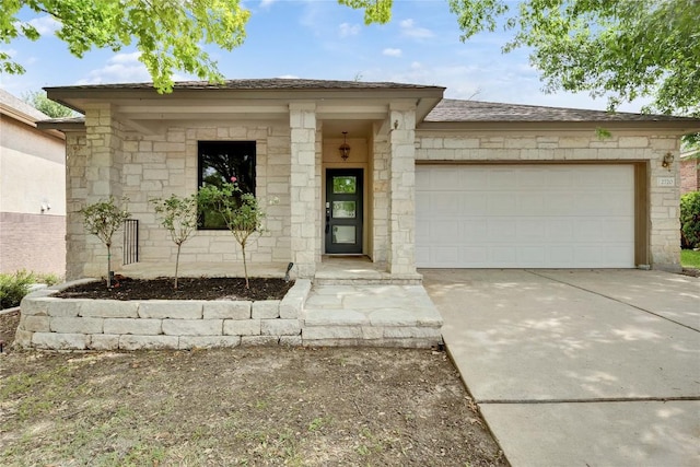 property entrance with a garage, driveway, and stone siding