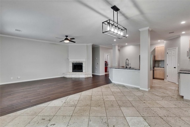 unfurnished living room featuring a sink, ornamental molding, recessed lighting, and ceiling fan