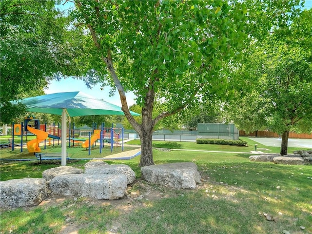 view of yard featuring fence and playground community