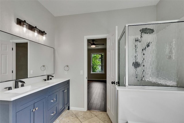 full bath with double vanity, baseboards, a sink, and a stall shower