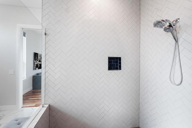 full bath with baseboards and tiled shower