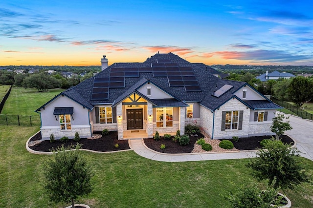 504 Loyal June Trl, Leander, TX 78641 - view of front of property with stone siding, roof with shingles, a chimney, roof mounted solar panels, and stucco siding