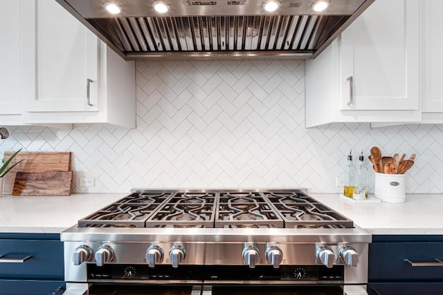 kitchen featuring stainless steel range with gas cooktop, backsplash, white cabinets, and custom exhaust hood