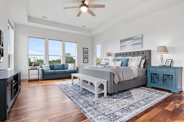 504 Loyal June Trl, Leander, TX 78641 - bedroom with a raised ceiling, dark wood-style flooring, ceiling fan, and baseboards