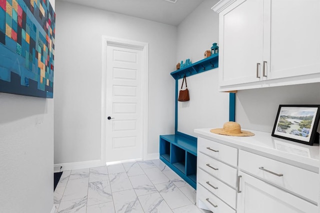 mudroom with baseboards and marble finish floor