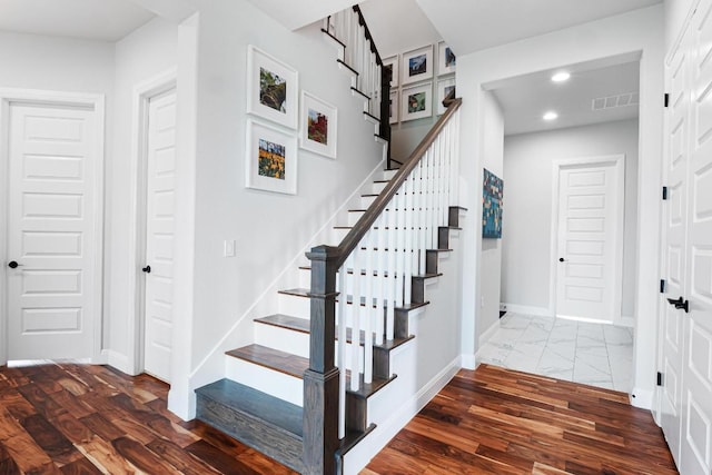 stairs featuring recessed lighting, baseboards, wood finished floors, and visible vents