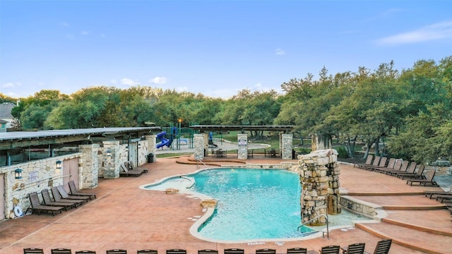community pool featuring a patio and playground community