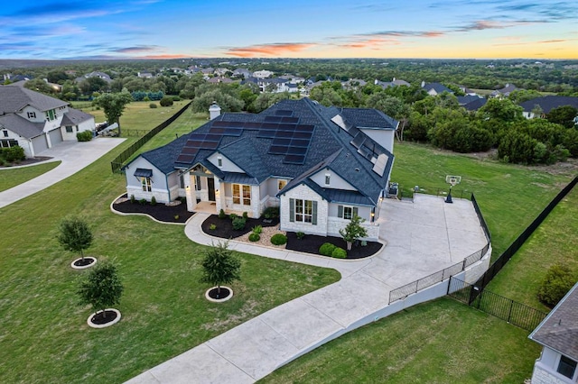 504 Loyal June Trl, Leander, TX 78641 - view of front of property with driveway, stone siding, a garage, a shingled roof, and roof mounted solar panels