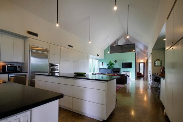 1145 Longhorn Dr, Burnet, TX 78611 - kitchen with dark countertops, appliances with stainless steel finishes, modern cabinets, high vaulted ceiling, and white cabinetry