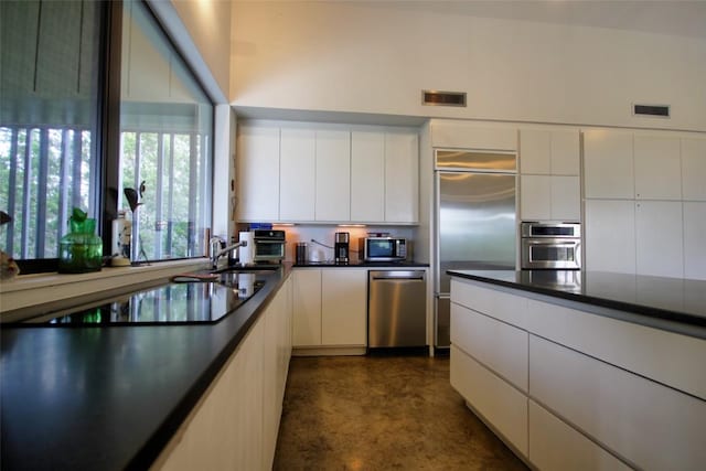 1145 Longhorn Dr, Burnet, TX 78611 - kitchen with appliances with stainless steel finishes, concrete floors, white cabinetry, and dark countertops