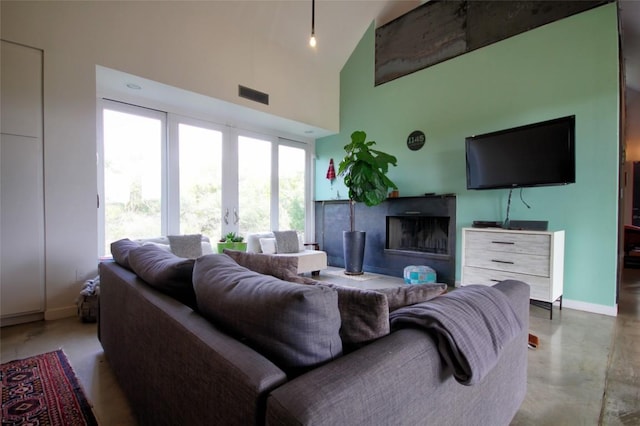 1145 Longhorn Dr, Burnet, TX 78611 - living area with baseboards, a high ceiling, a fireplace, and concrete floors
