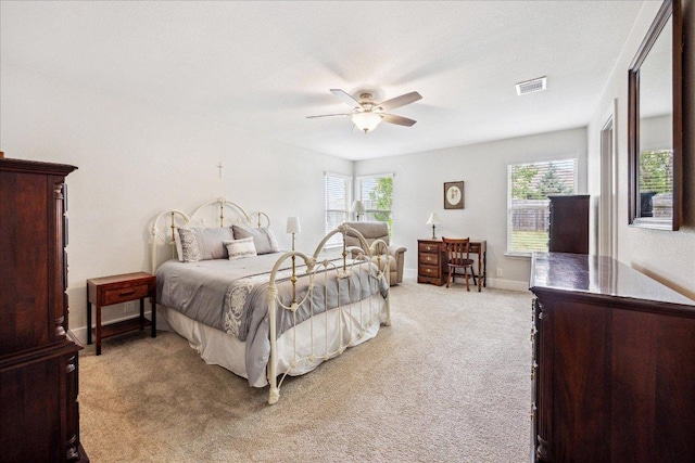 bedroom with ceiling fan, visible vents, multiple windows, and carpet