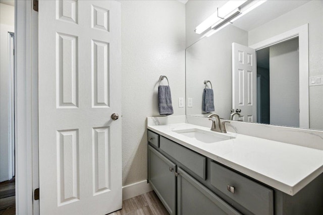 bathroom featuring vanity, baseboards, and wood finished floors
