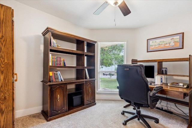 office space with light colored carpet, baseboards, and ceiling fan