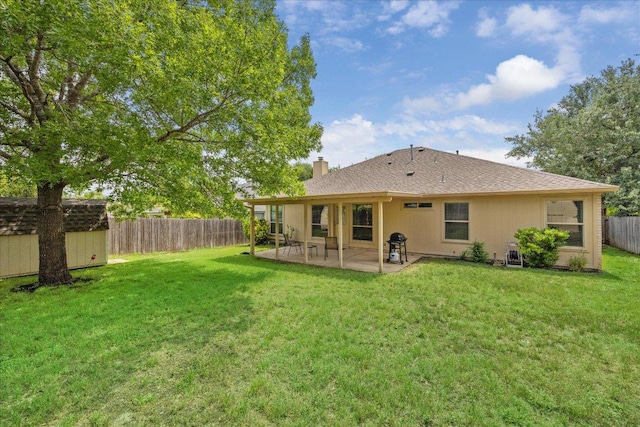 back of house featuring a shed, a fenced backyard, an outbuilding, a chimney, and a patio area