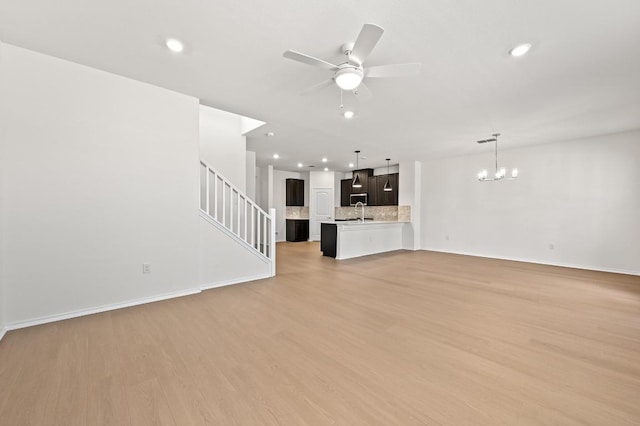 12126 Cantabria Rd, Austin, TX 78748 - unfurnished living room with a chandelier, recessed lighting, ceiling fan, light wood-style floors, and stairway