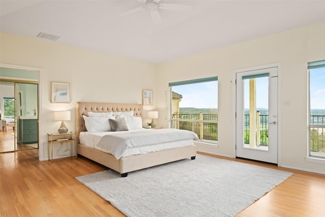 bedroom featuring a ceiling fan, access to exterior, wood finished floors, and visible vents