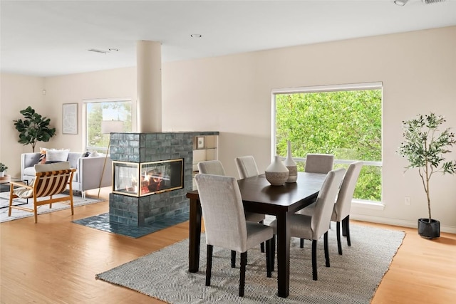 5926 N W Pl, Austin, TX 78731 - dining space with wood finished floors, a tile fireplace, and baseboards