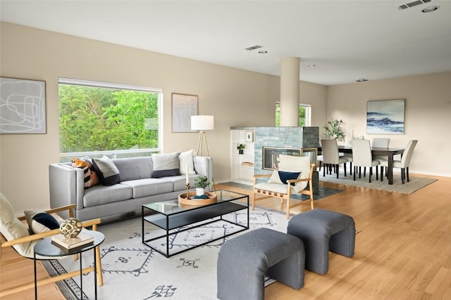 living area featuring baseboards, wood finished floors, and visible vents