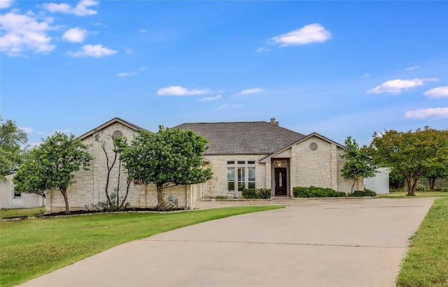 3606 Bunyan Cir, Lago Vista, TX 78645 - view of front of home with stone siding, a front lawn, and curved driveway