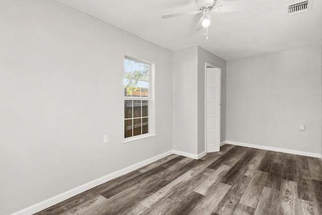 unfurnished bedroom with baseboards, ceiling fan, dark wood finished floors, and visible vents