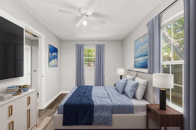 bedroom with baseboards, ceiling fan, and wood finished floors