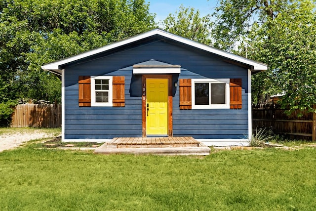 bungalow-style home featuring fence and a front lawn