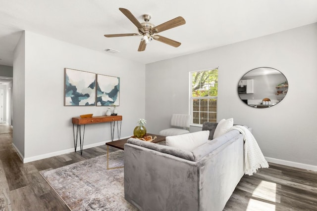 living room with a ceiling fan, baseboards, visible vents, and wood finished floors