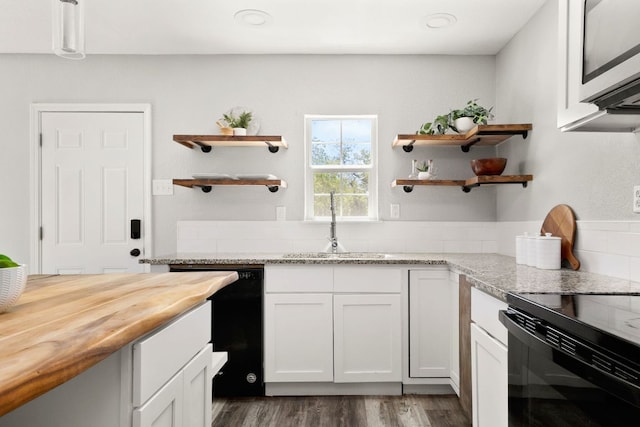 kitchen featuring open shelves, butcher block countertops, black appliances, and dark wood-type flooring