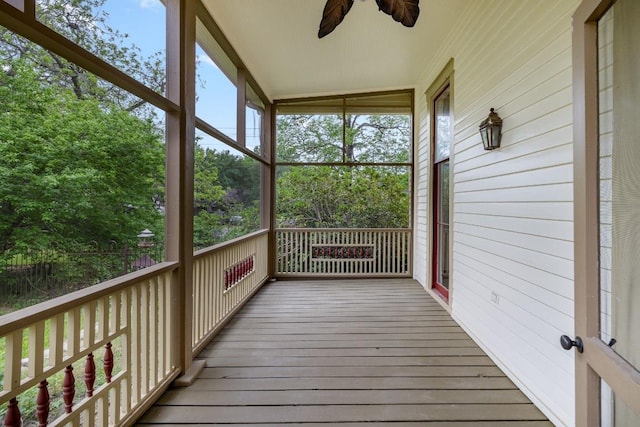 unfurnished sunroom featuring a ceiling fan