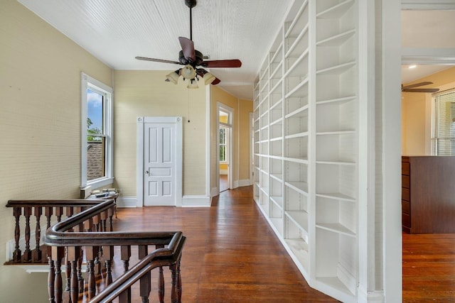 hallway featuring baseboards and wood finished floors