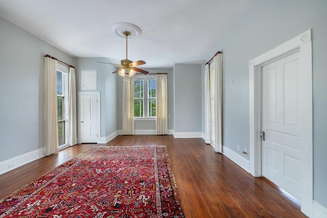 spare room with baseboards, a ceiling fan, and wood finished floors