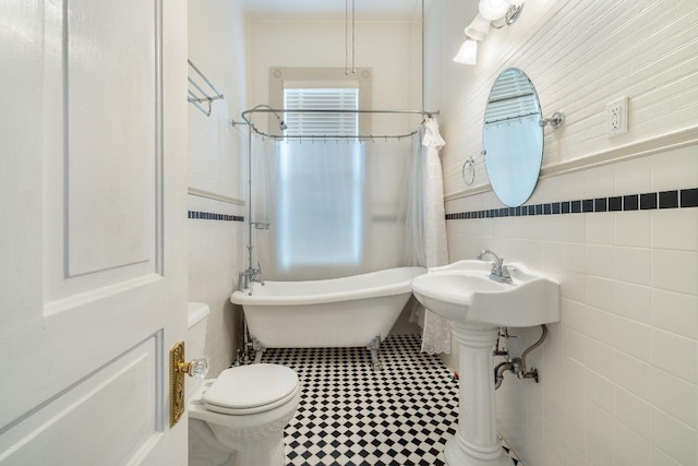 full bathroom with toilet, tile walls, ornamental molding, and a wainscoted wall