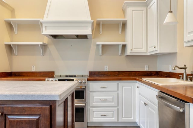 kitchen featuring a sink, premium range hood, open shelves, and stainless steel appliances