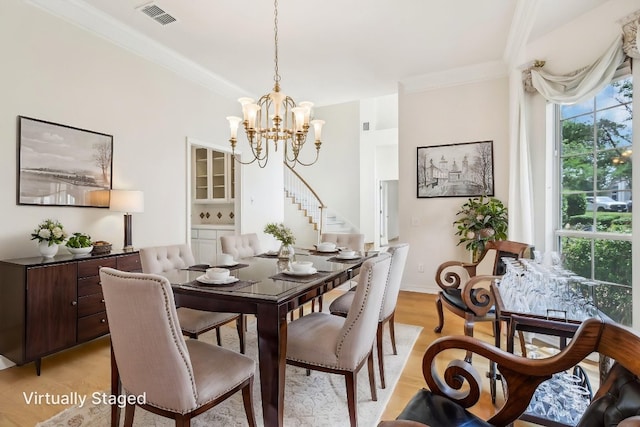 7100 Valburn Dr, Austin, TX 78731 - dining space featuring a chandelier, crown molding, light wood-type flooring, and stairs