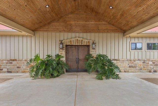 doorway to property with board and batten siding and stone siding