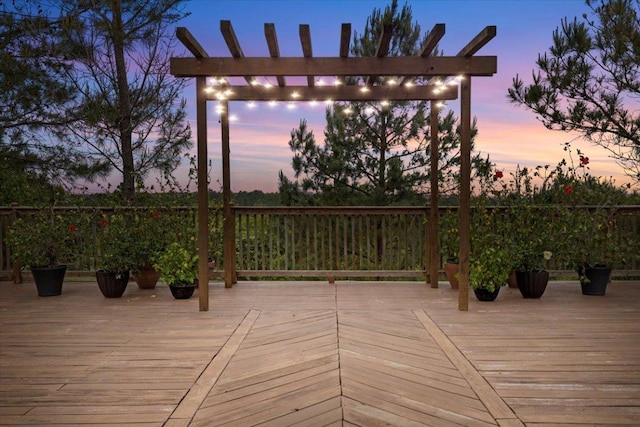 deck at dusk featuring a pergola