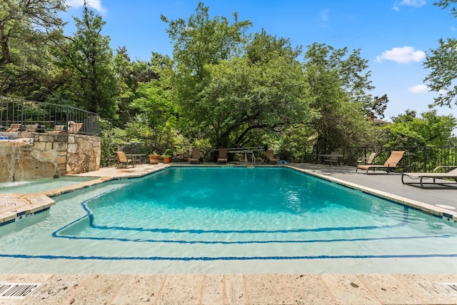 community pool featuring a patio and fence
