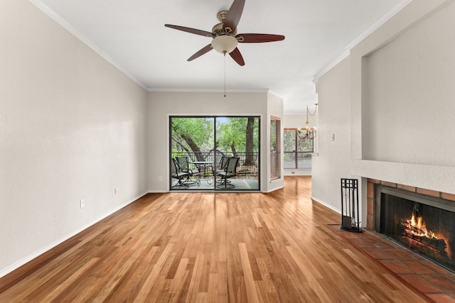 unfurnished living room featuring baseboards, ceiling fan with notable chandelier, a tile fireplace, and wood finished floors