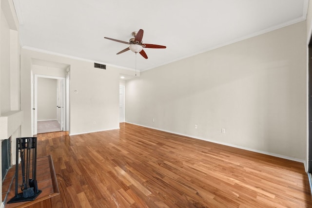 unfurnished living room with crown molding, a ceiling fan, baseboards, wood finished floors, and visible vents