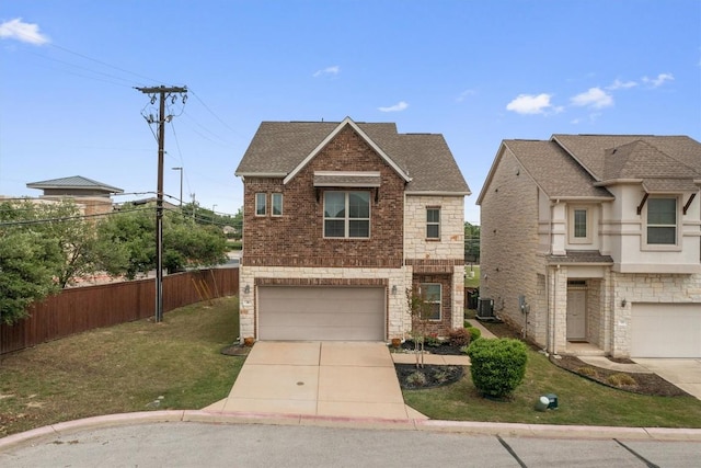 2105 Town Centre Dr Unit 36, Round Rock, TX 78664 - view of front facade featuring an attached garage, concrete driveway, stone siding, brick siding, and a shingled roof