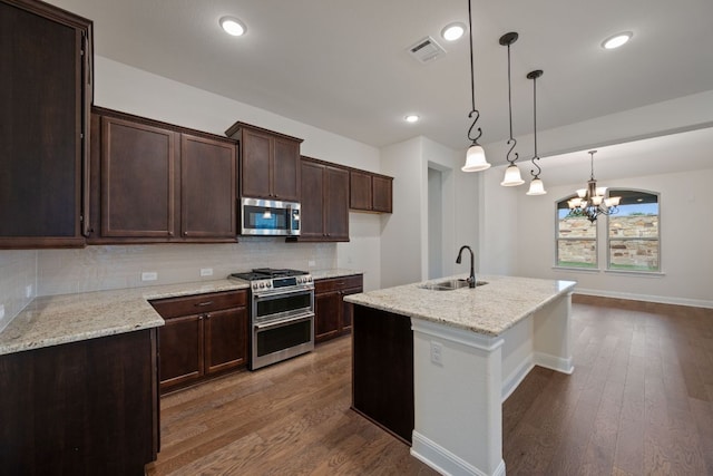 kitchen featuring a sink, tasteful backsplash, stainless steel appliances, and wood finished floors