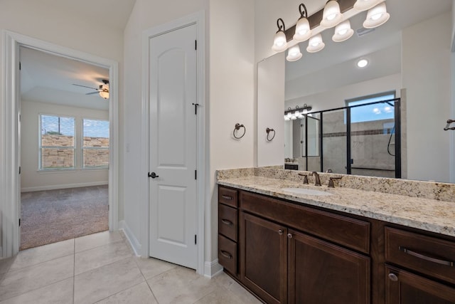 full bathroom featuring vanity, tile patterned flooring, baseboards, ceiling fan, and a stall shower