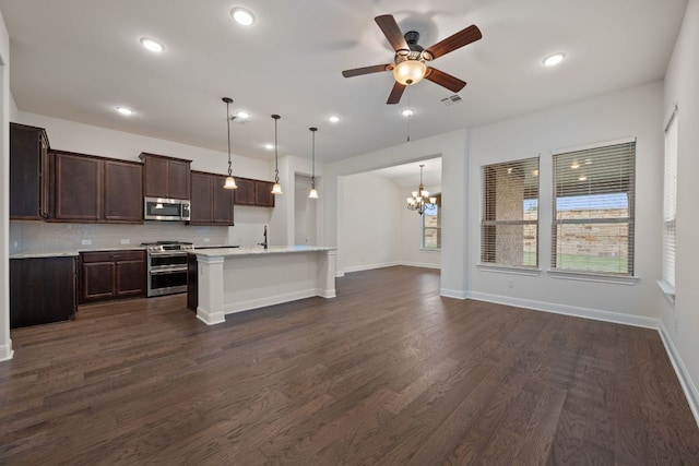 kitchen with dark brown cabinets, open floor plan, light countertops, backsplash, and stainless steel appliances