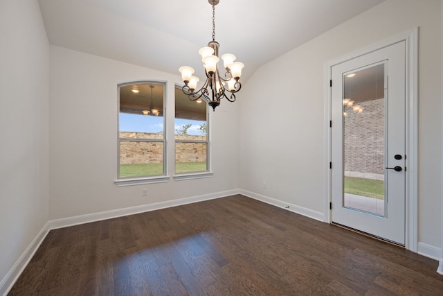 spare room featuring baseboards, an inviting chandelier, and dark wood-type flooring