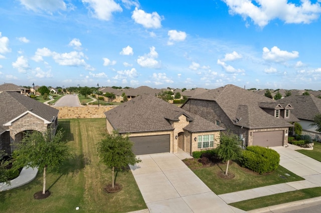 view of front of house with brick siding, a garage, driveway, and a residential view